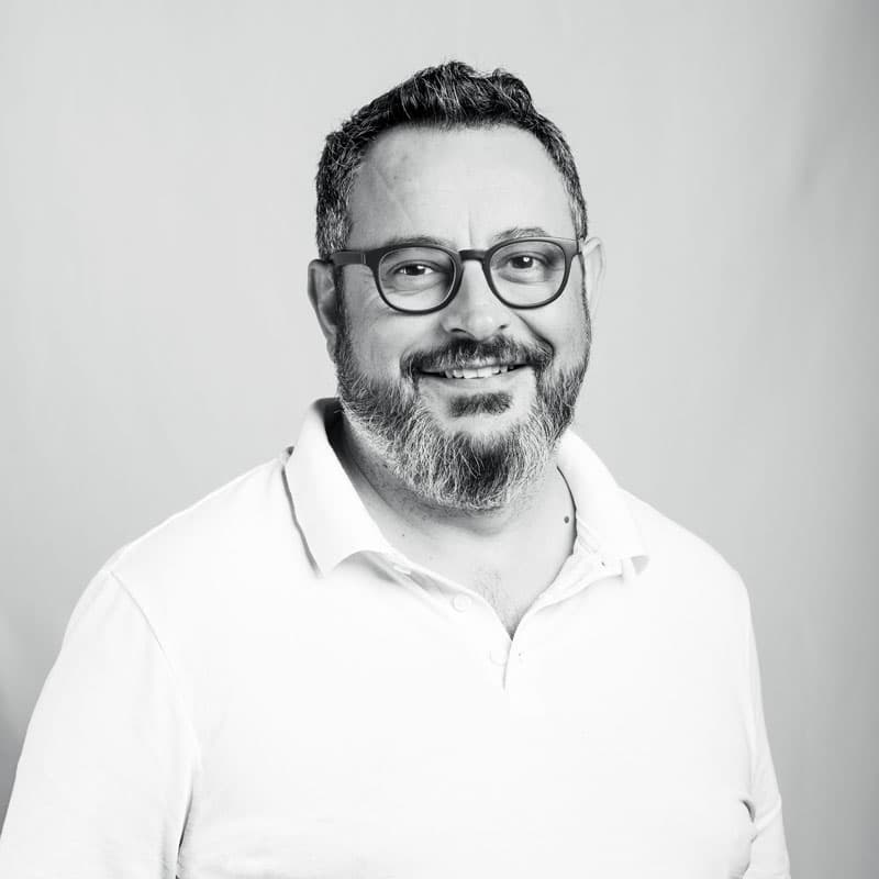Portrait noir et blanc d'un homme barbu avec lunettes, style corporate