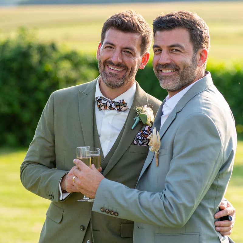 Couple élégant trinquant au champagne lors d'un mariage champêtre